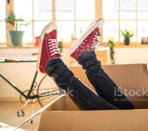 Person in a moving box with just their feet sticking out.